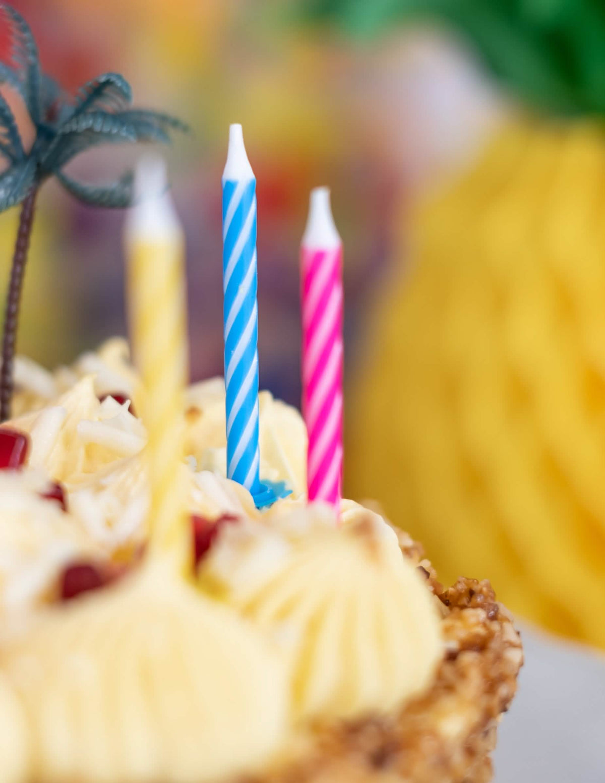 Detalhe das velas com suportes sobre um bolo das 10 velas de aniversário coloridas para festa multicolores