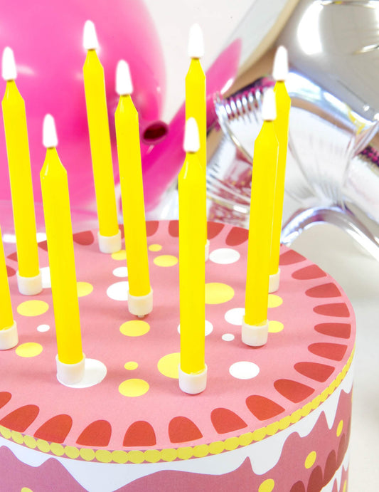 Grande plano sobre as velas amarelas das velas coloridas para aniversário multicoloridas
