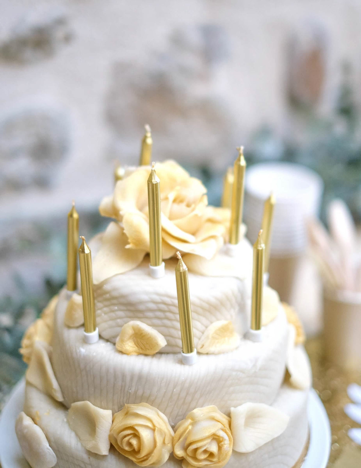 Cenário sobre um bolo com velas de aniversário douradas metalizadas