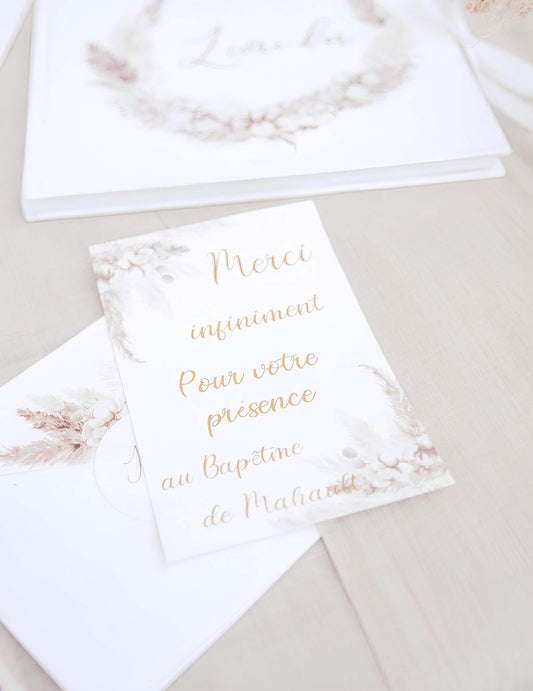 Gros plan sur le texte des invitations avec enveloppes pampas et fleurs de coton