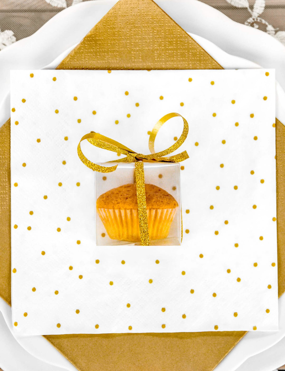 Mise em cena com um cupcake das pequenas caixas para presentes para convidados transparentes
