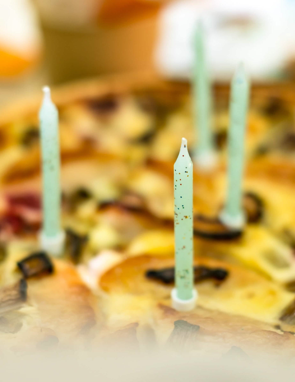 Foco na disposição num bolo das velas de menta com brilho para aniversário