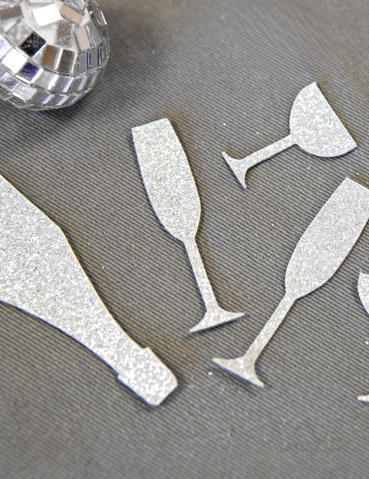Grande plano sobre a textura brilhante dos confettis de mesa champanhe prateados, copos e flautas