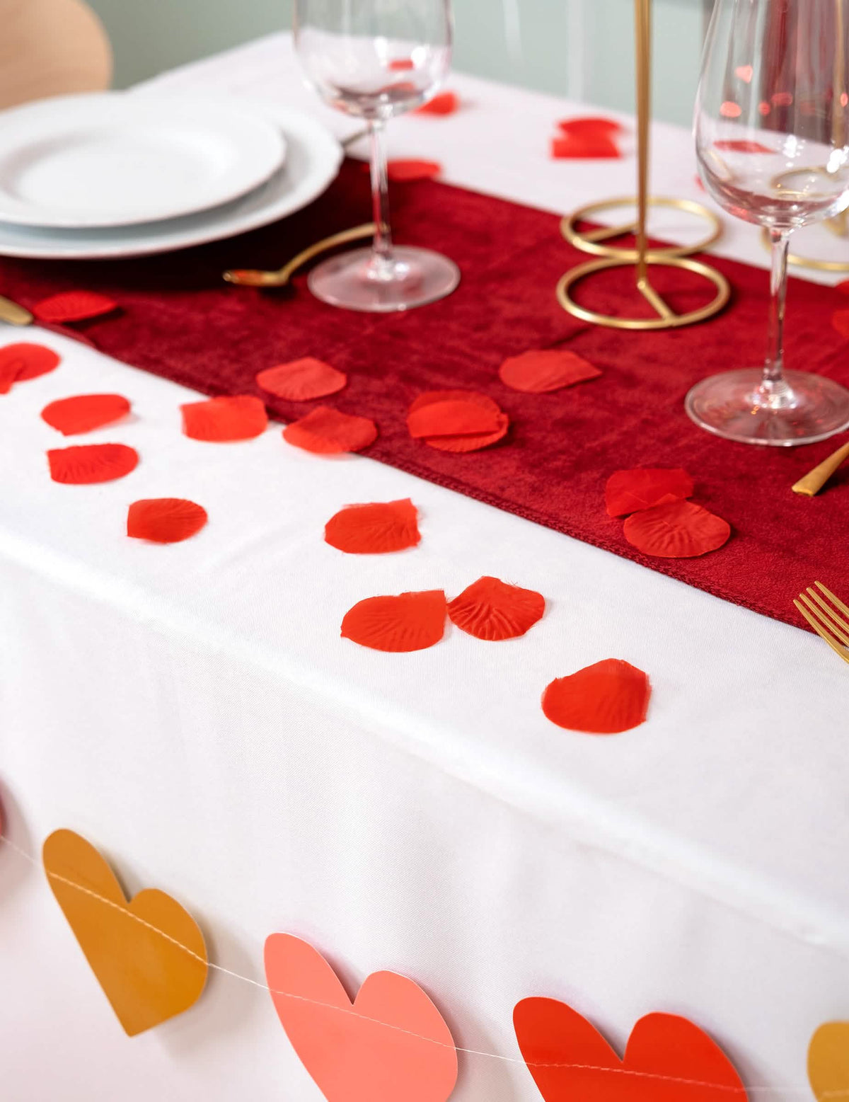 Encenação sobre uma mesa de pétalas de vermelho em tecido para festa vermelho