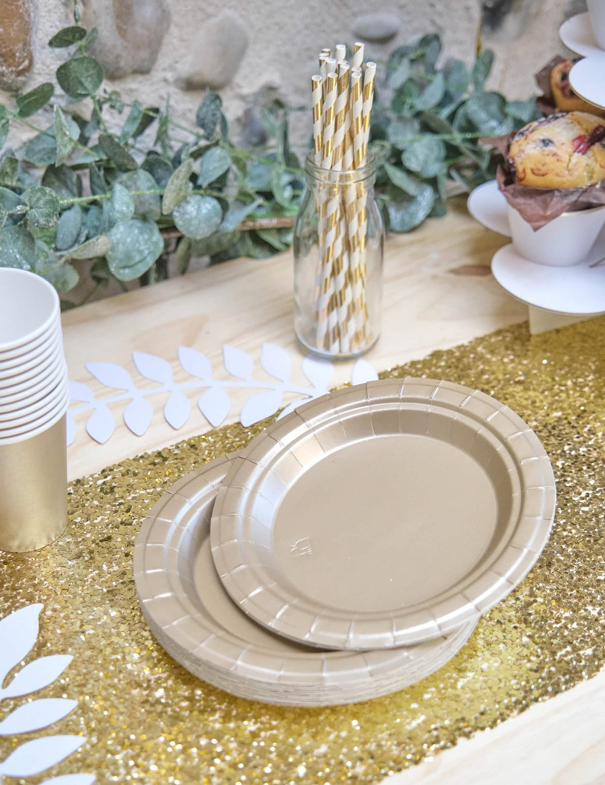 Encenação numa mesa de pequenos pratos de cartão para festa dourado mate
