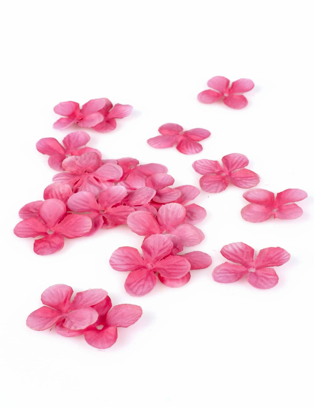 Detalhe das decorações de mesa pétalas de flores fúcsia em tecido