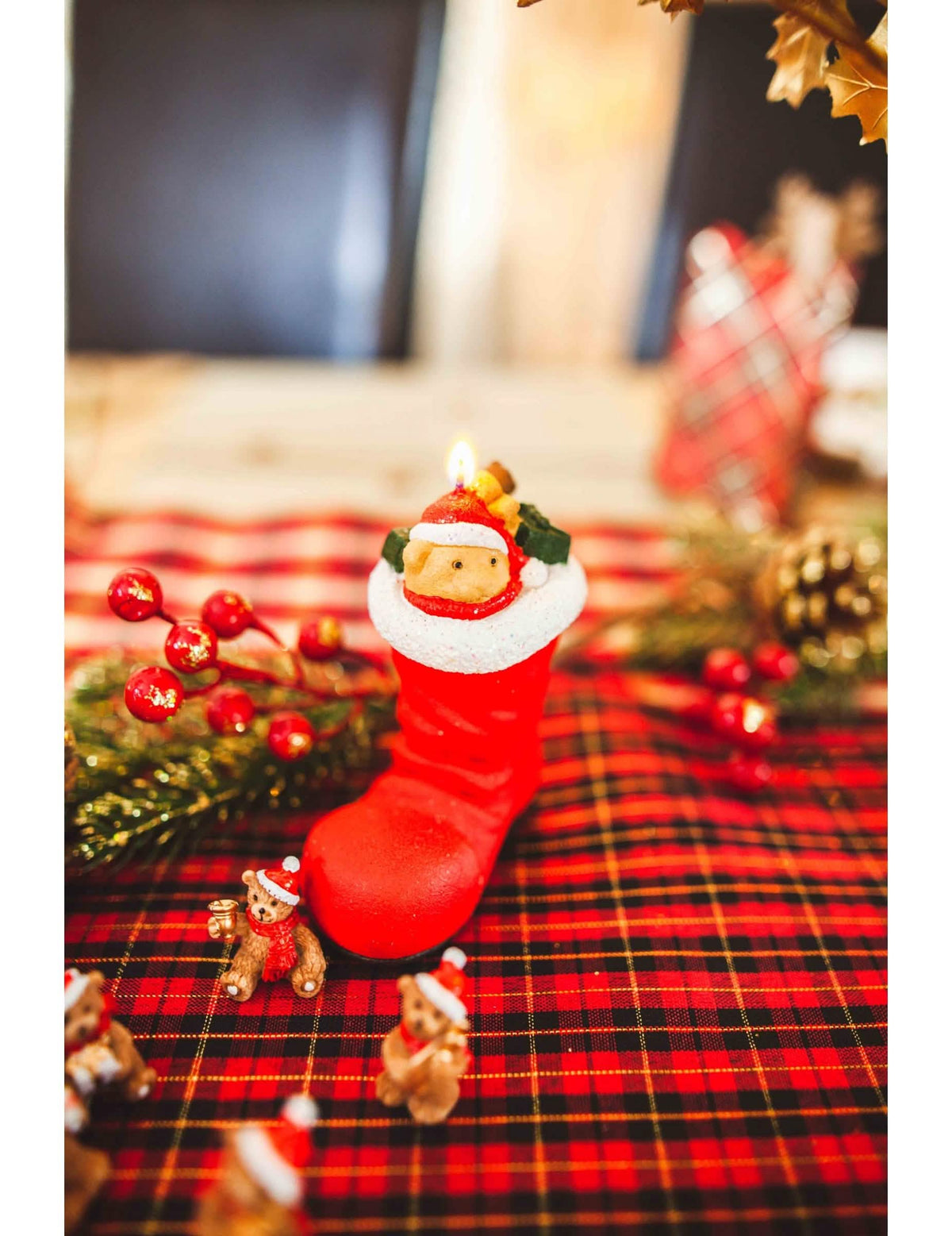 Mise em situação sobre mesa decorada das 3 velas bota do pai natal com ursinho