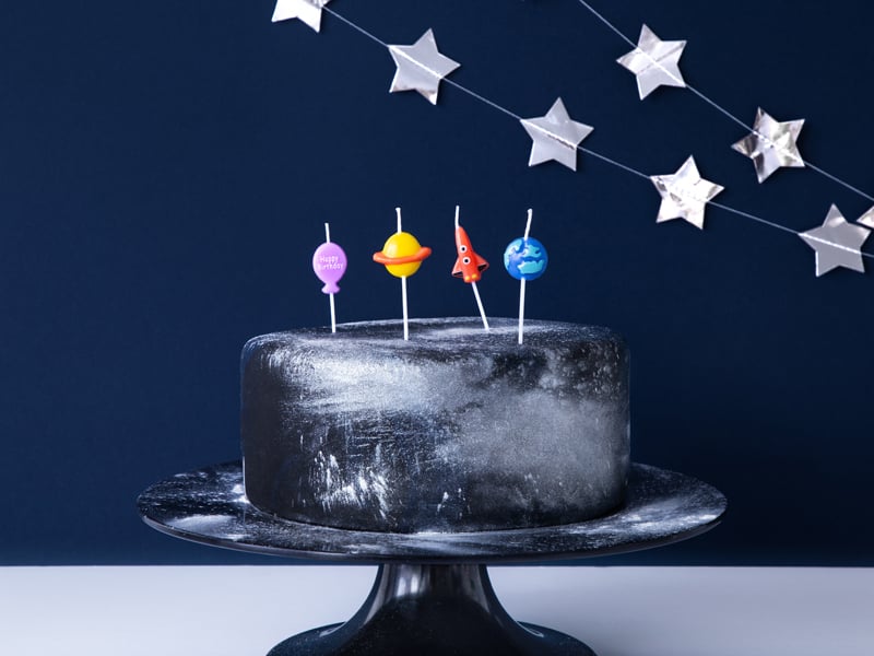 Decoração de um bolo com 4 velas de aniversário espaço foguetão e planeta
