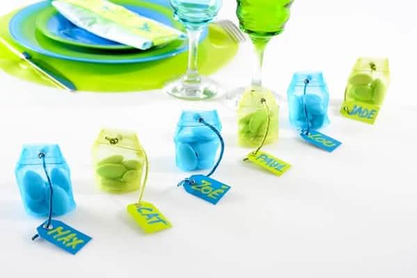 Encenação em mesa de festa do recipiente em saco de organdi para amêndoas açucaradas turquesa