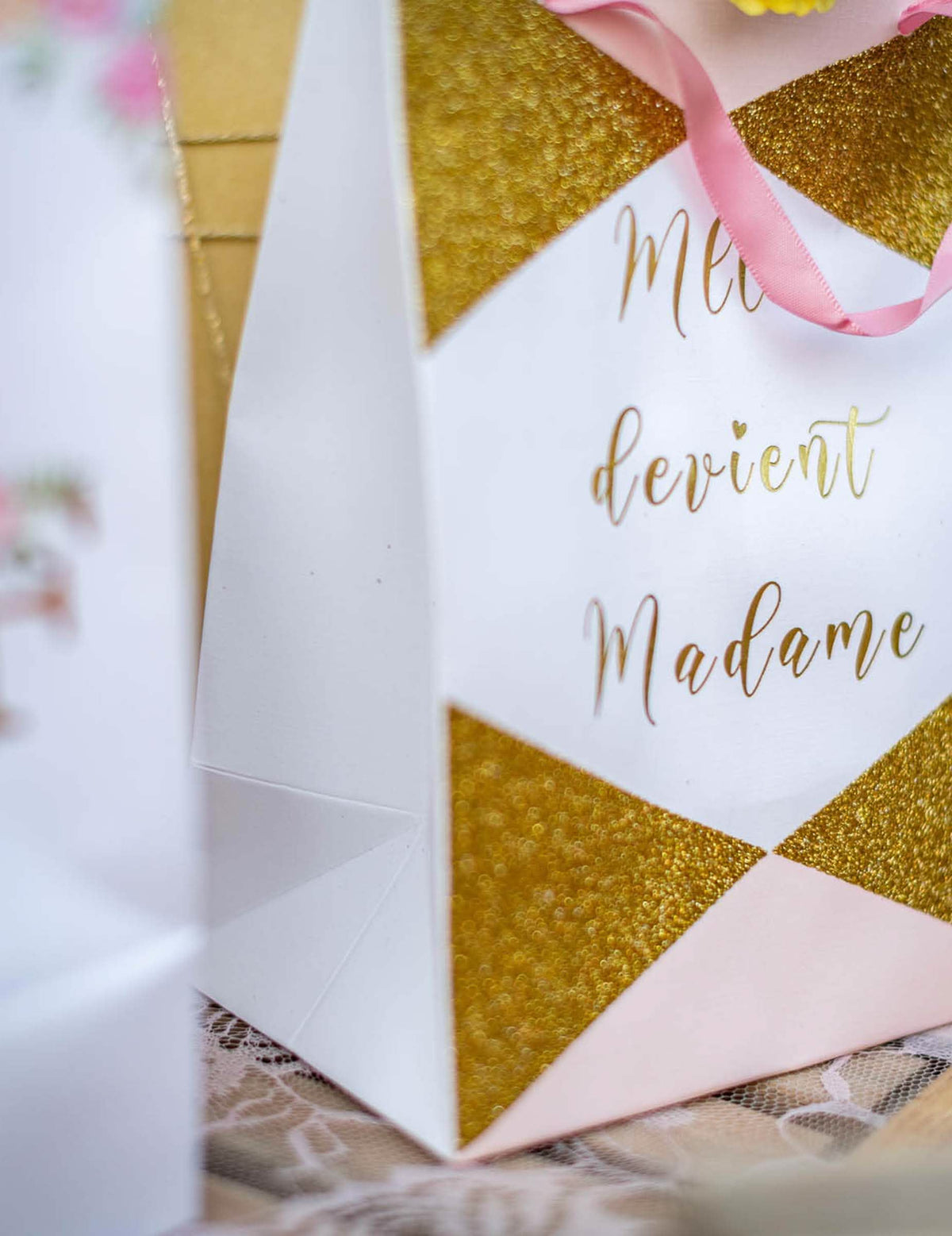 Grande plano dos detalhes com brilhantes e da inscrição da sacola de cartão “Mlle devient madame” para futura noiva