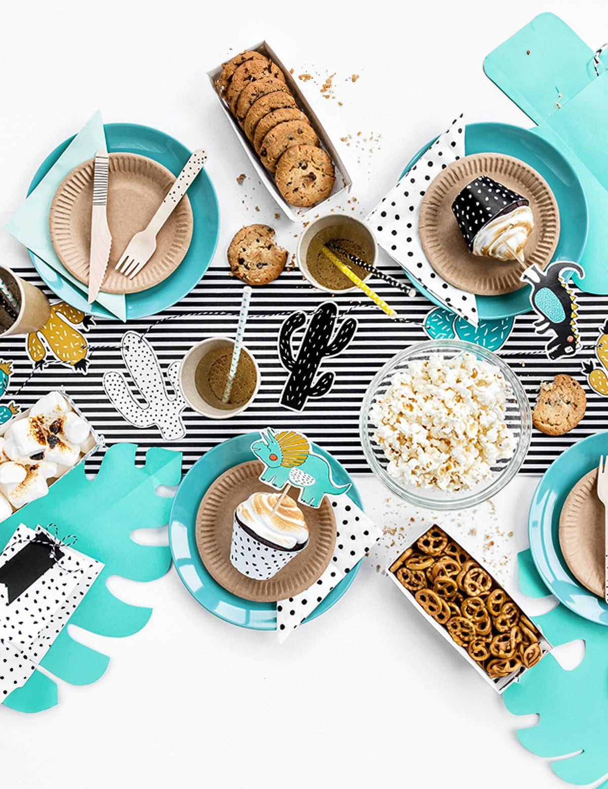 Vista geral da decoração de mesa dos cake toppers em cartão dinossauros