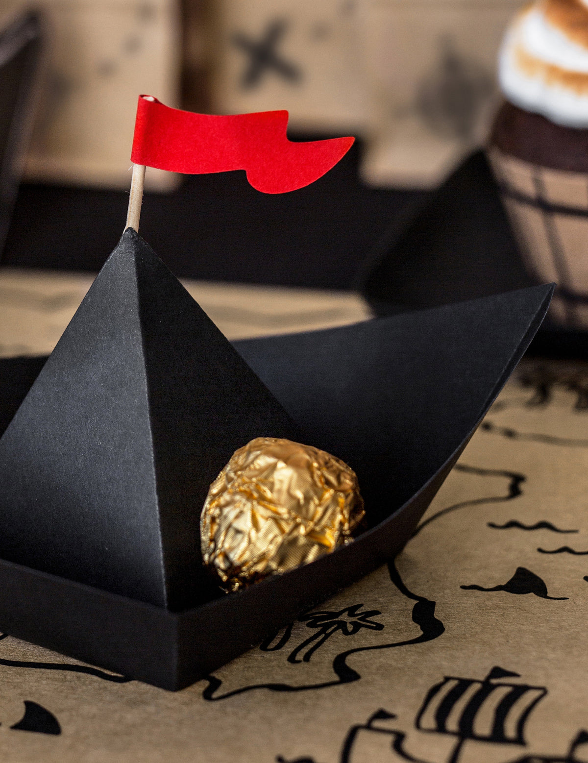 Chocolat doré placé à l'intérieur du bateau de pirate en papier origami pirate