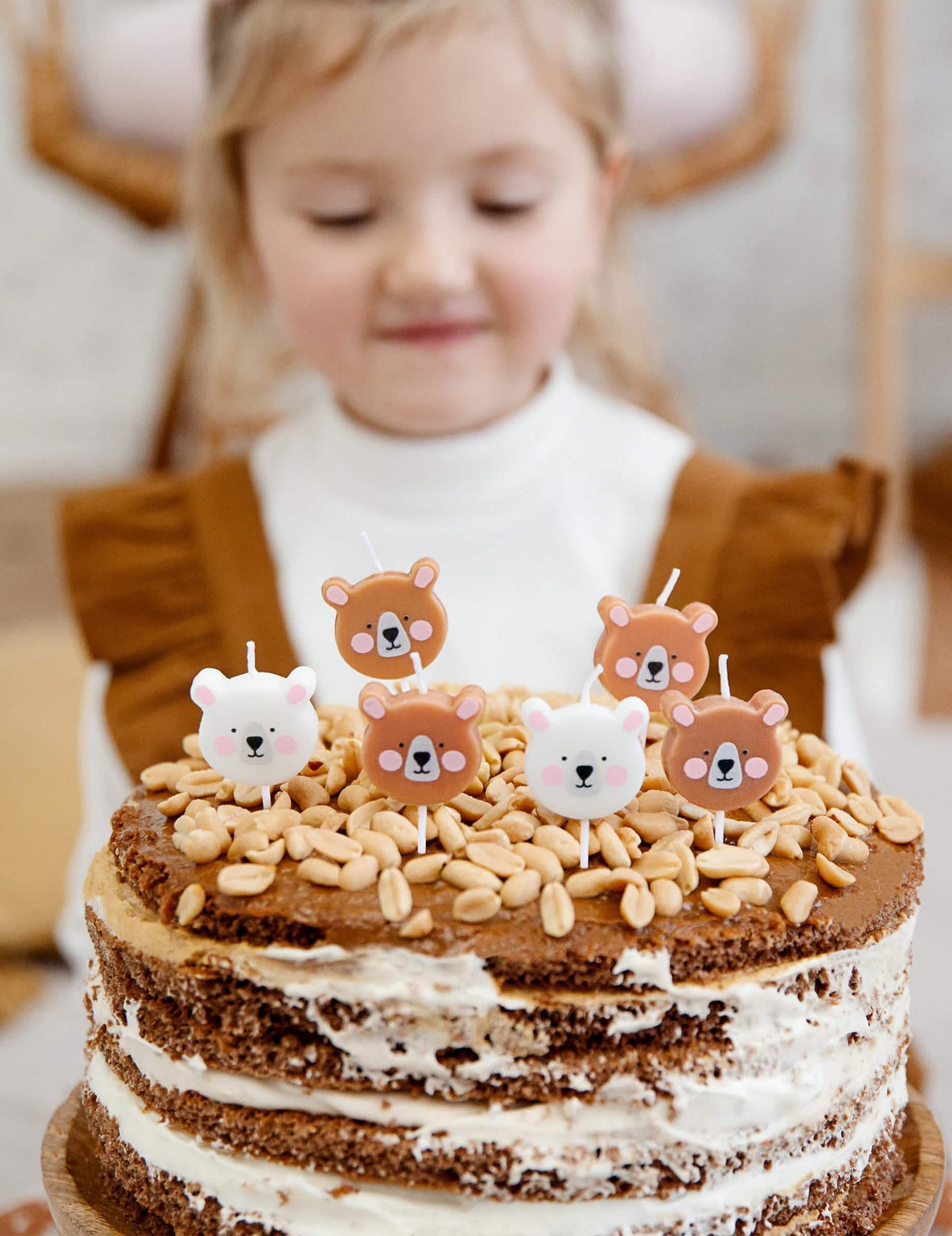 Cenario sobre um bolo com velas de aniversário pequenos ursos