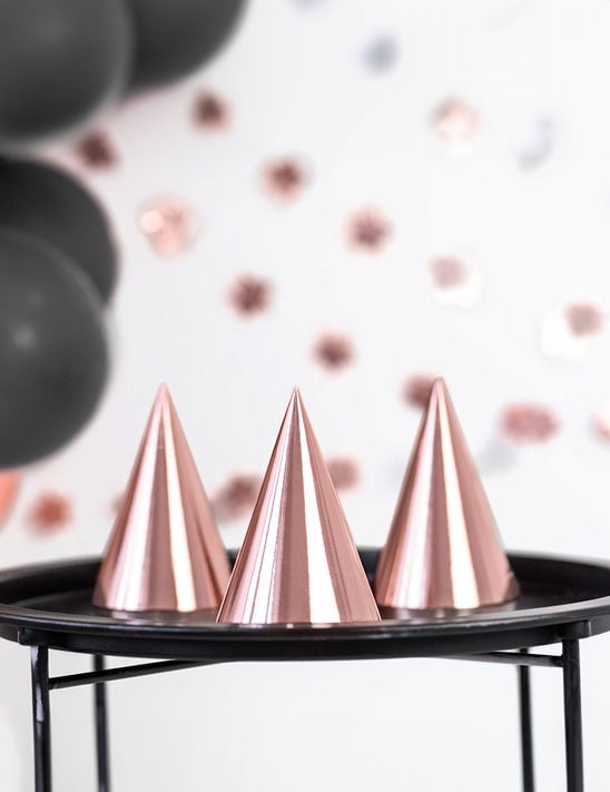 Gros plan sur la finition des chapeaux de fête pour anniversaire rose gold métallisé en carton