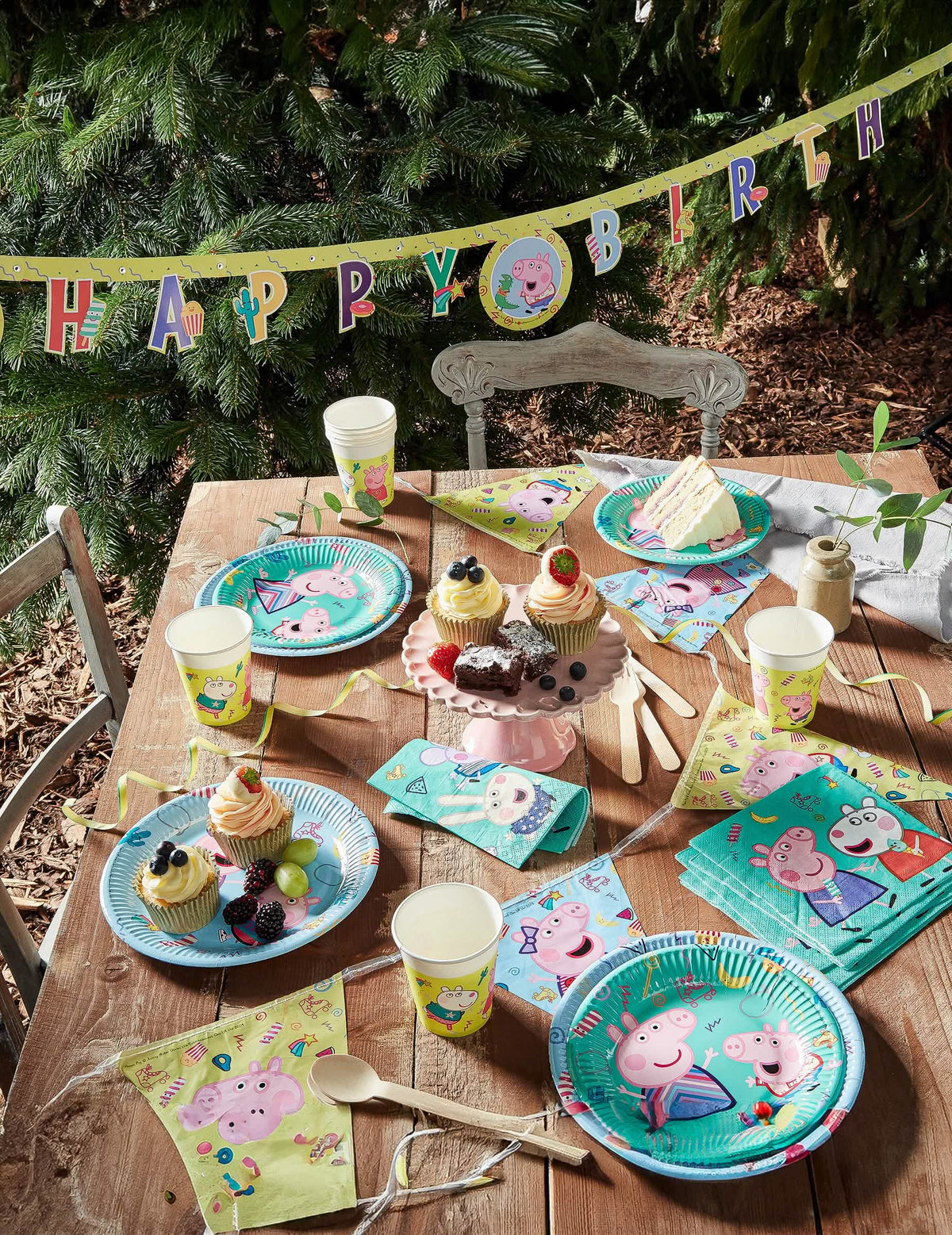 Vista geral da mesa de festa com grinalda de copos de cartão Peppa Pig