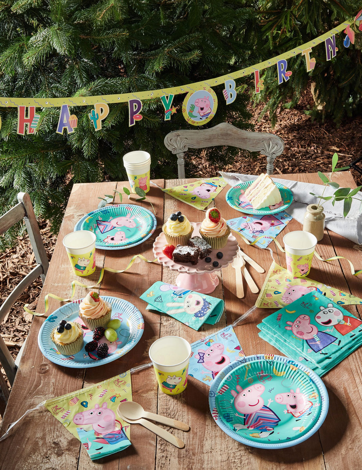 Vista geral da mesa de festa com os pequenos pratos de cartão Peppa Pig