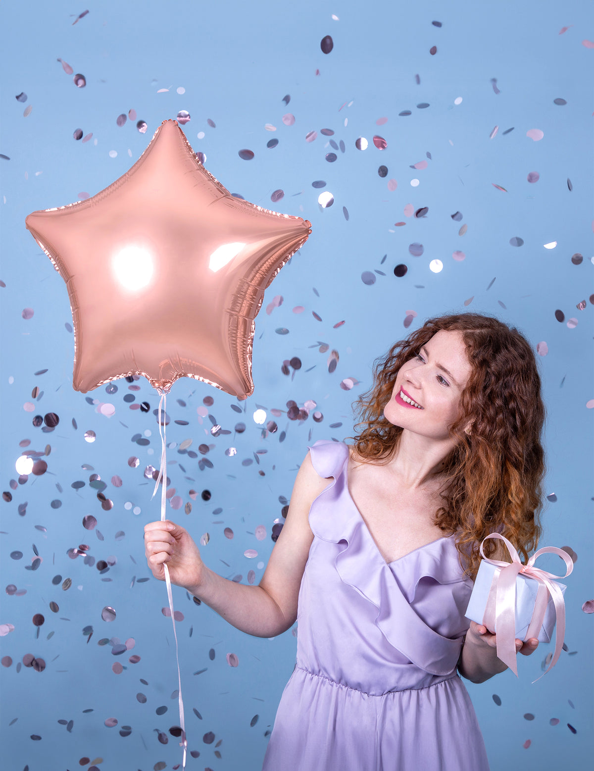 Mise en situation avec une femme du ballon aluminium étoile pour décoration de fête rose gold métallisé