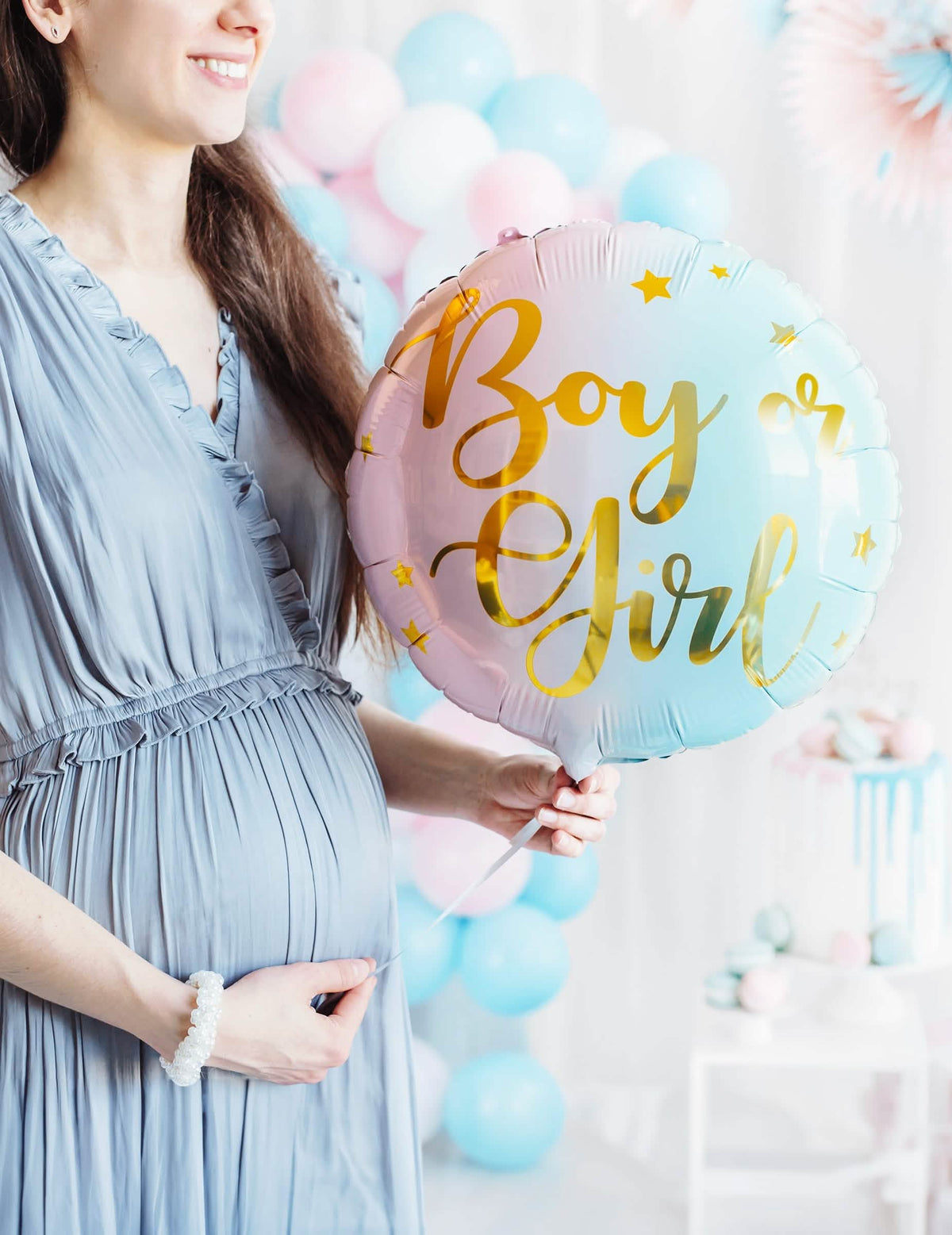 Cenário com uma mulher grávida com o balão de alumínio boy or girl para gender reveal