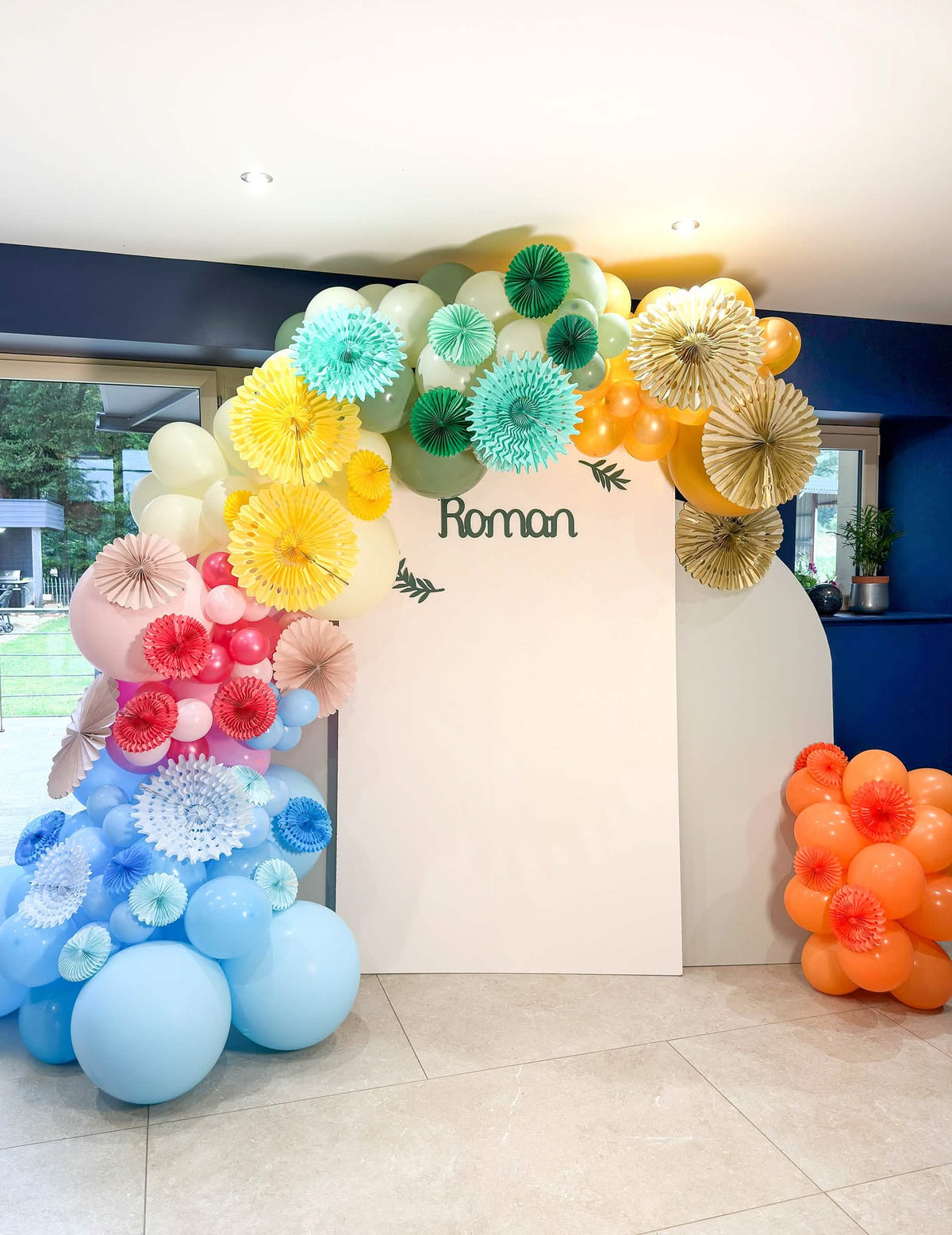 Arco de balões multicores e rosetas em papel do balão em latex gigante para festa azul