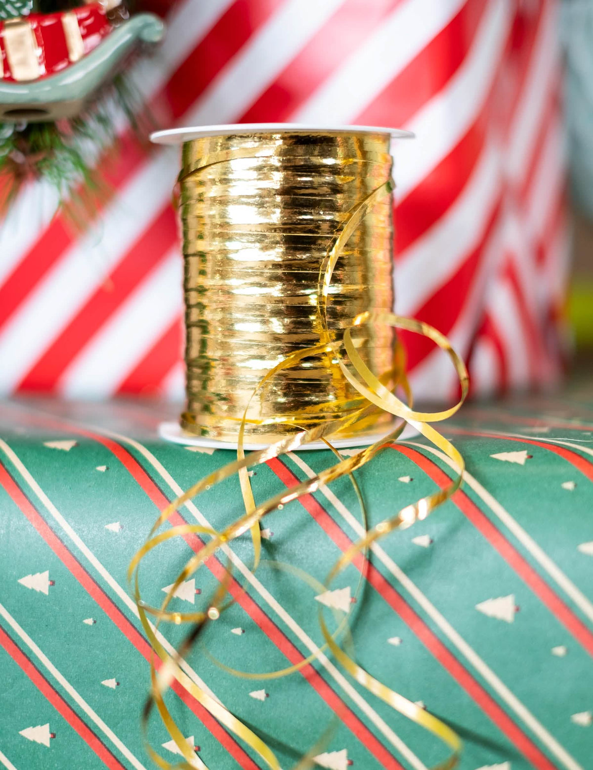Cena de encenação em pacotes de presentes do Bolduc brilhante para decoração de festa dourado