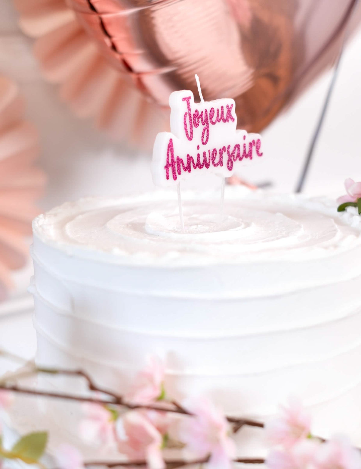 Colocação sobre um bolo da vela sobre palito Feliz aniversário