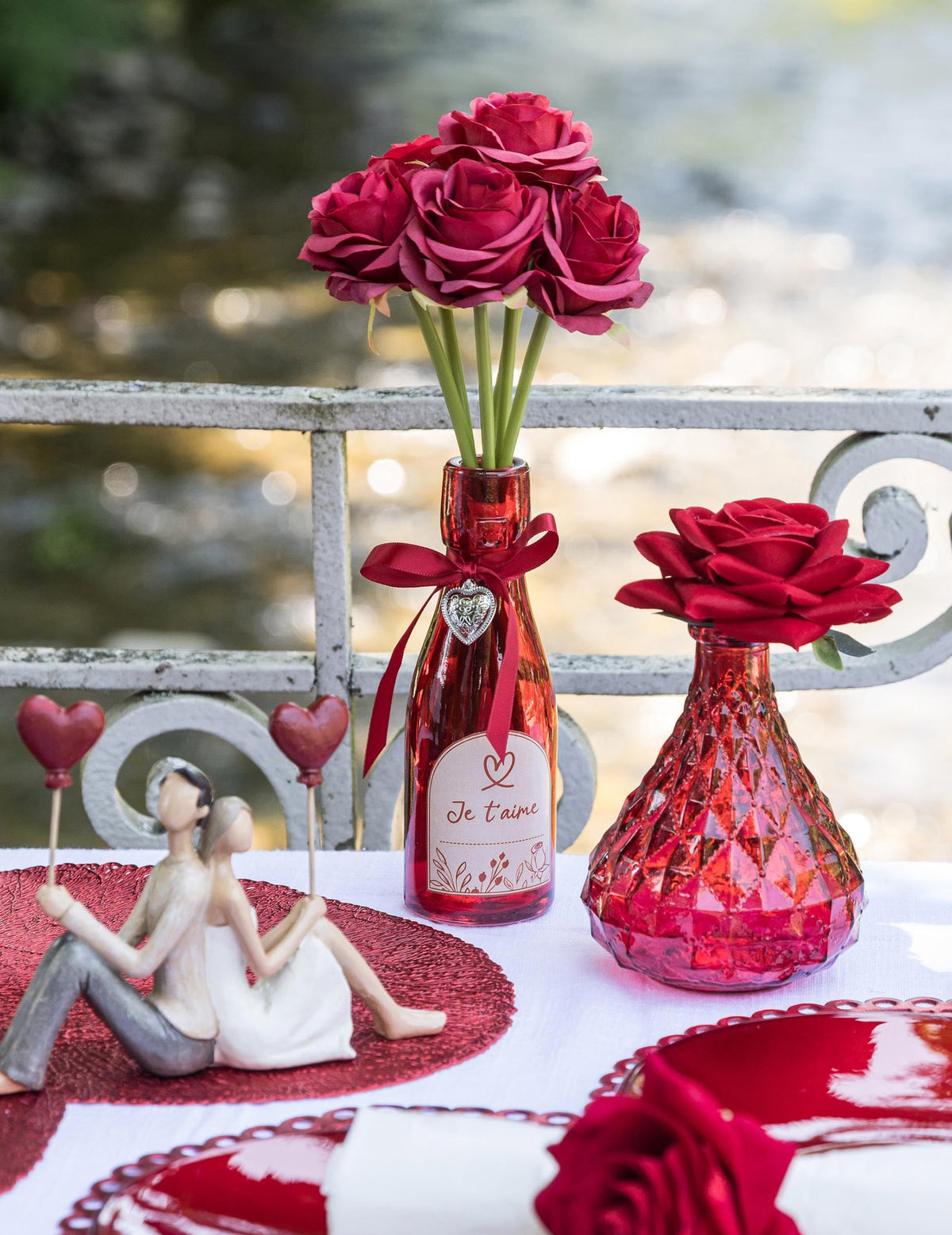 Mise en scène avec fleurs de la bouteille en verre coeur Je t'aime rouge