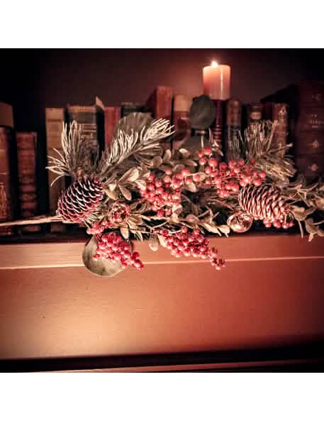 Colocação numa prateleira do ramo decorativo de eucalipto, sinos e pinhas