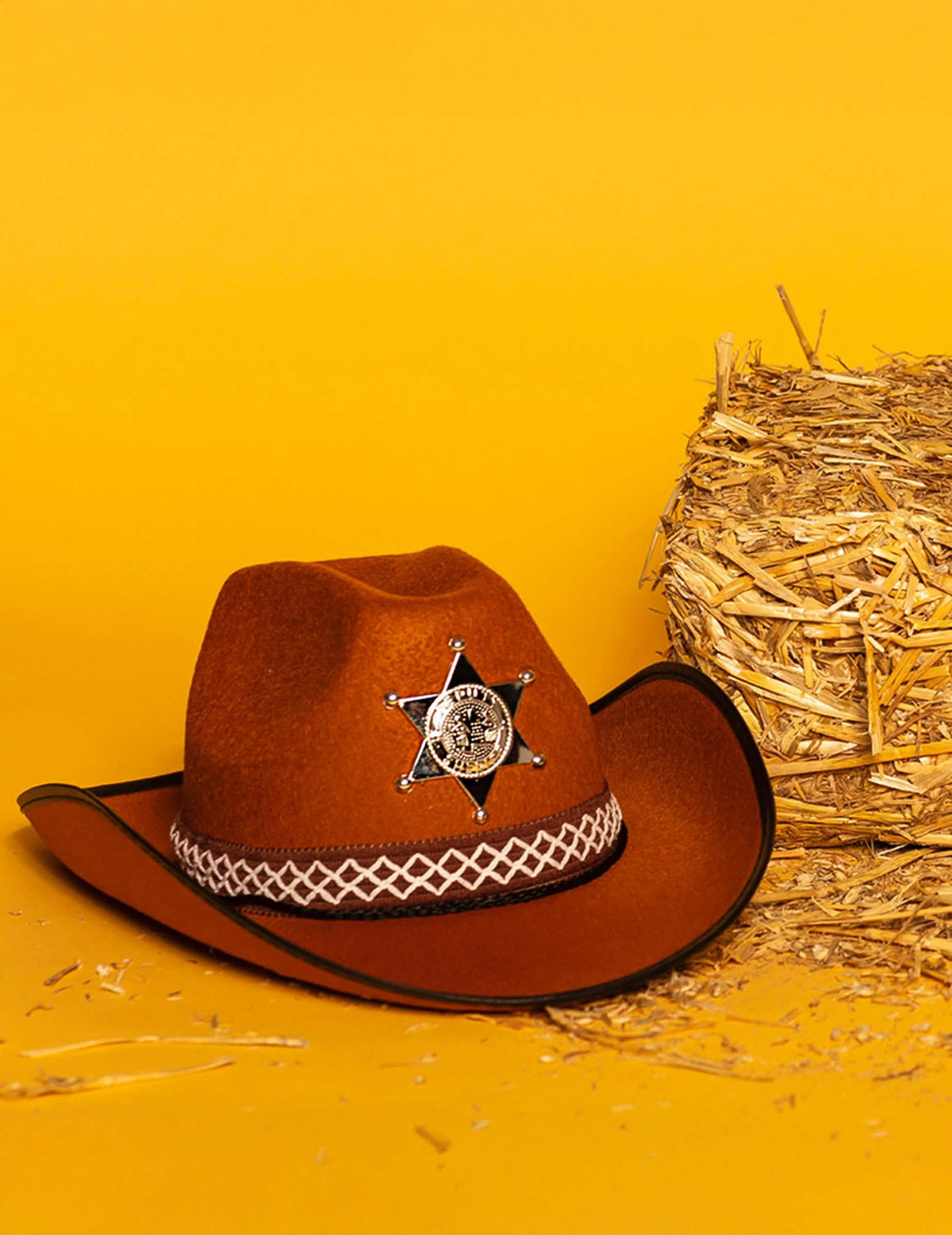 Mise en scène avec botte de paille du chapeau de sheriff pour enfant