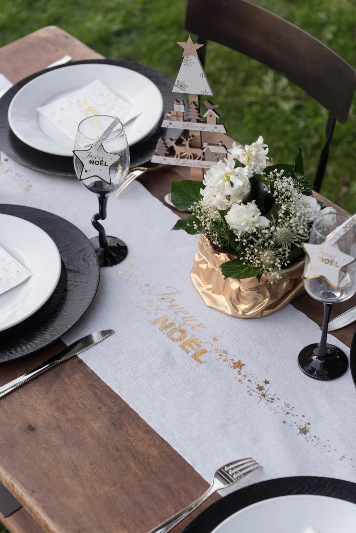 Colocação numa mesa de festa do caminho de mesa em algodão Feliz natal