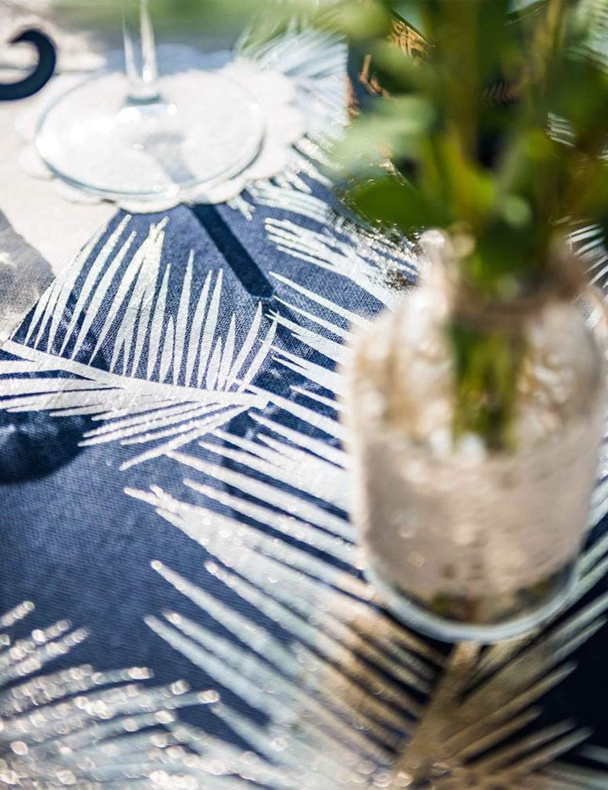 Grande plano dos motivos dourados do elegante caminho de mesa em linho com fetos