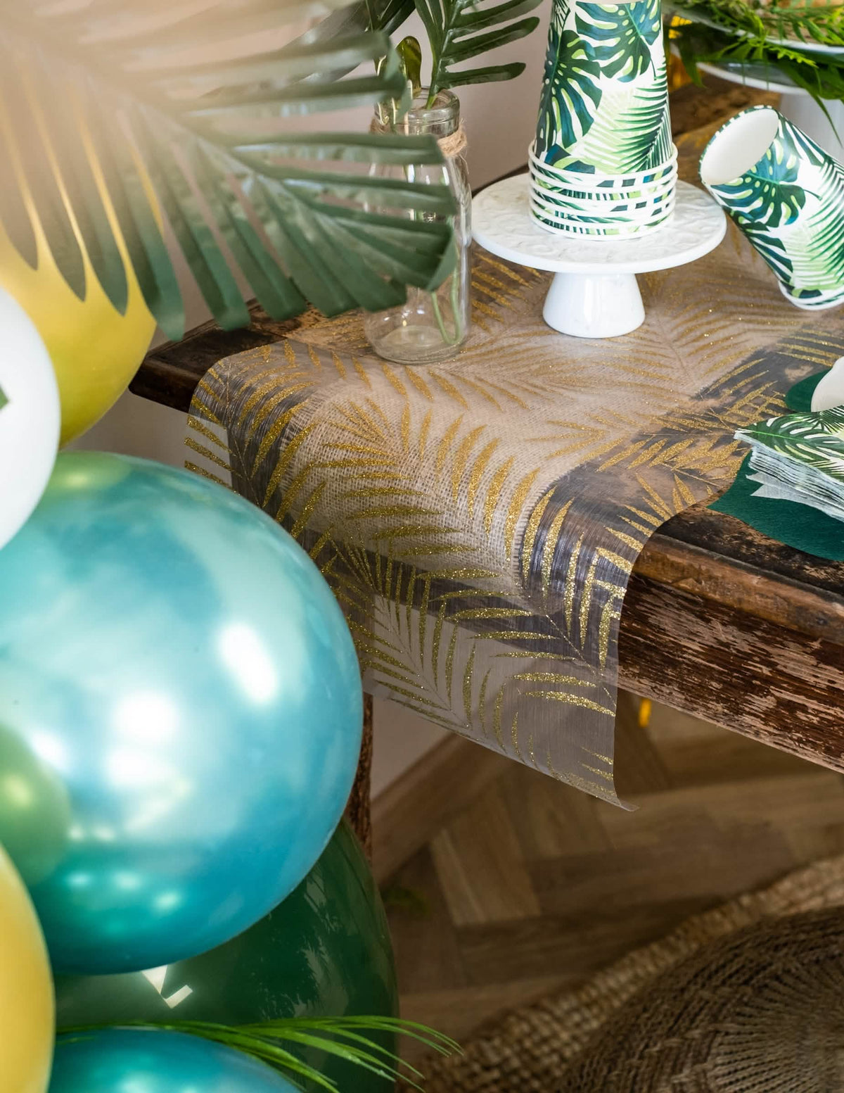 Colocação do caminho de mesa em organza com palmeira para decoração tropical chique