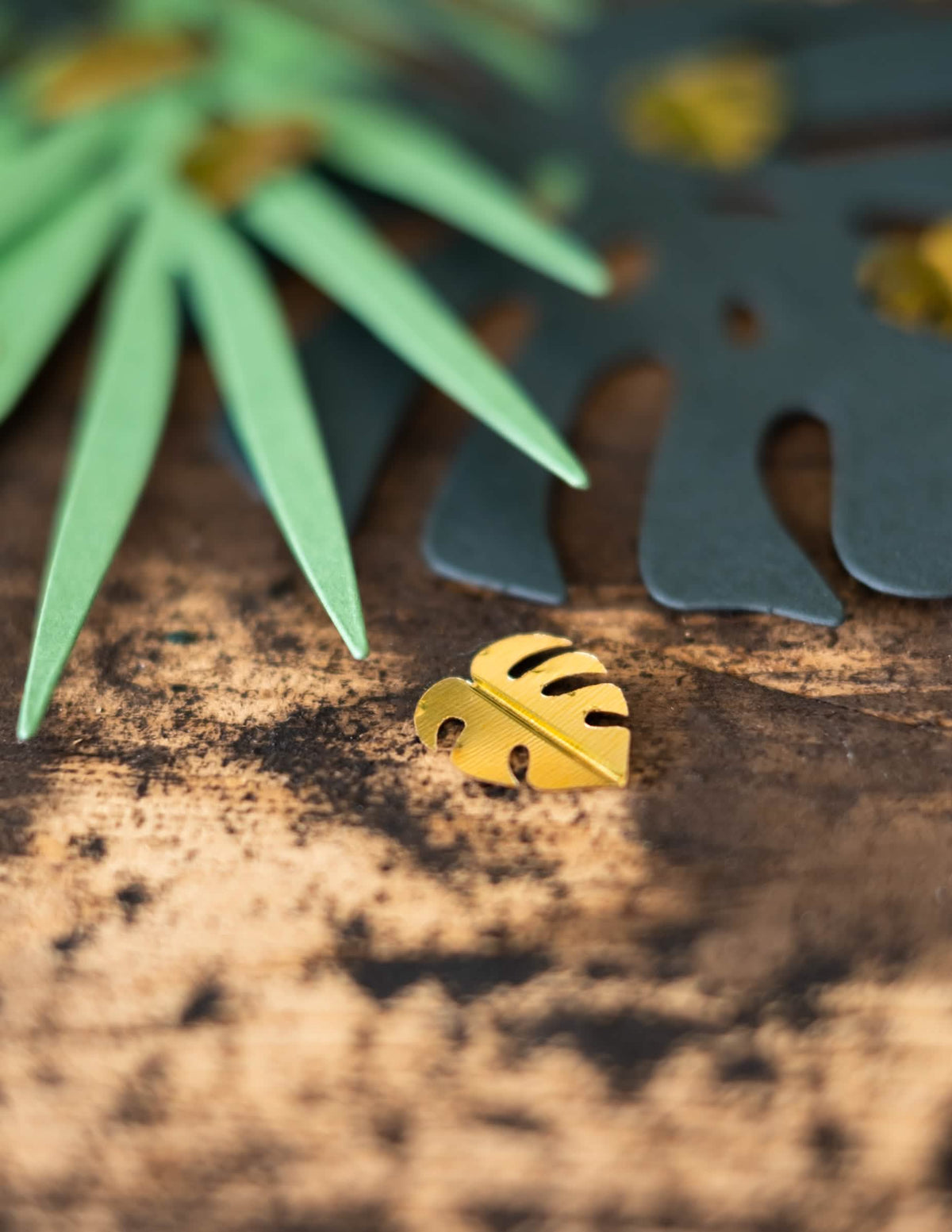 Grande plano de uma folha dourada de monstera dos confettis de mesa folhas tropicais