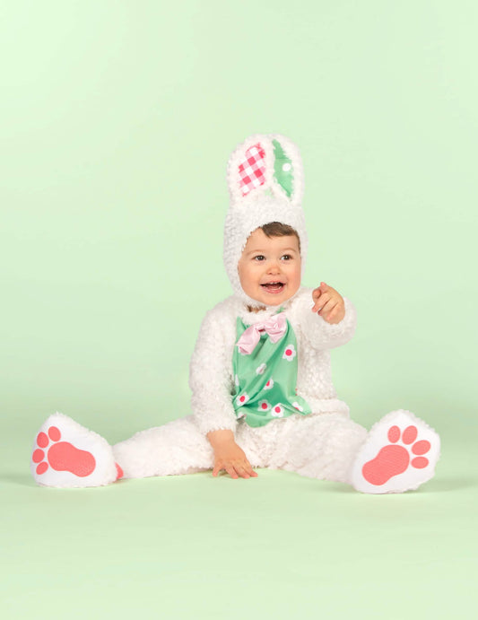 Bébé assis pointant du doigt du déguisement de lapin pour bébé