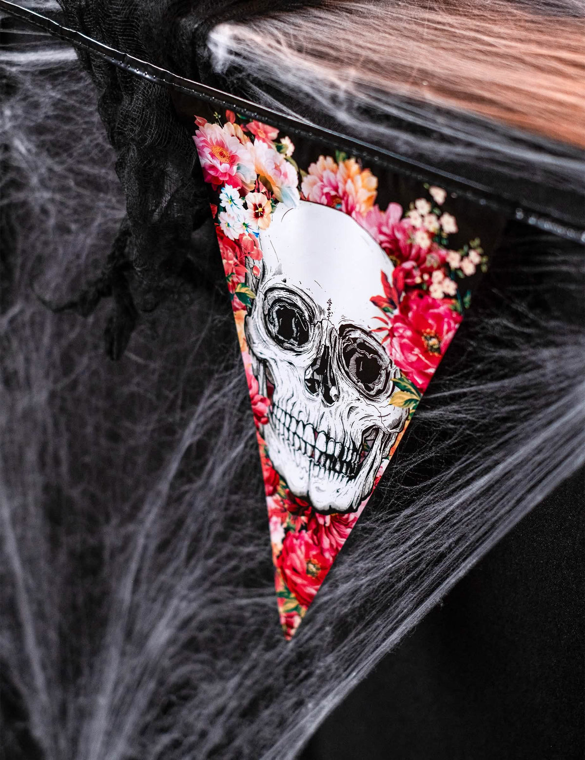 Detalhe do motivo de caveira e flores da grinalda de plástico esqueleto florido