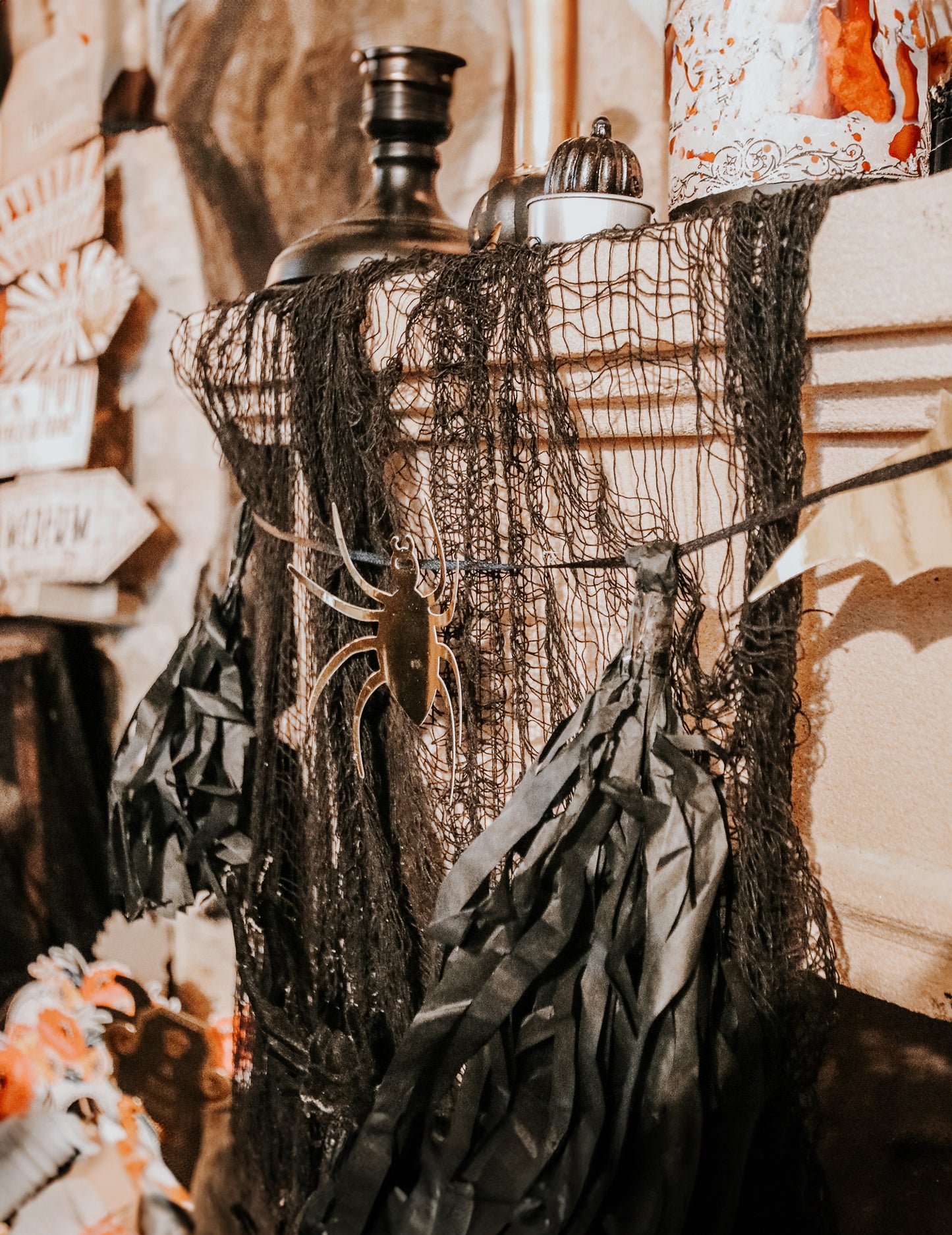 Détail des tassels noirs et de l'araignée dorée de la guirlande Halloween noire et or avec tassels