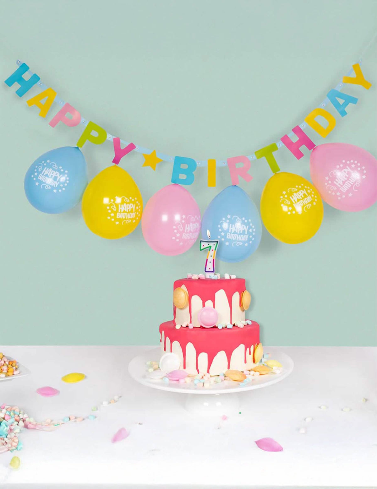 Mise em cena com bolo e balões da grinalda de letras Happy Birthday