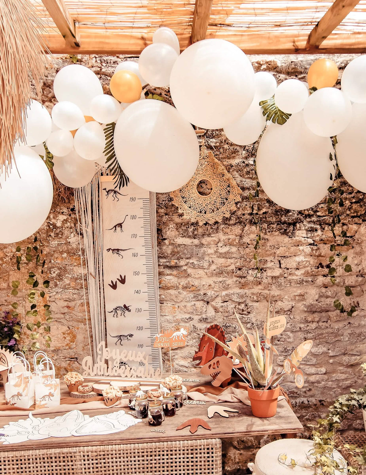 Mise em situação do kit arco de 55 balões branco e dourado com hera e folhas tropicais