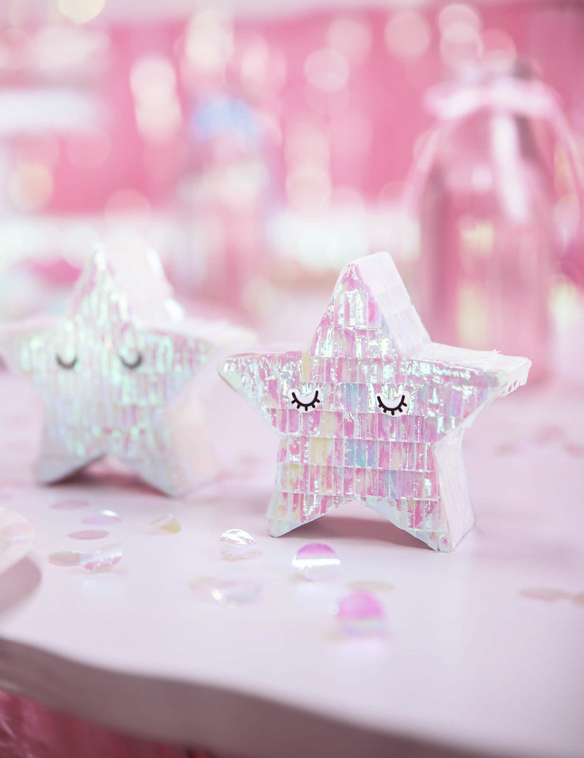 Vista aproximada sobre fundo cor de rosa da mini piñata estrela para decoração iridescente