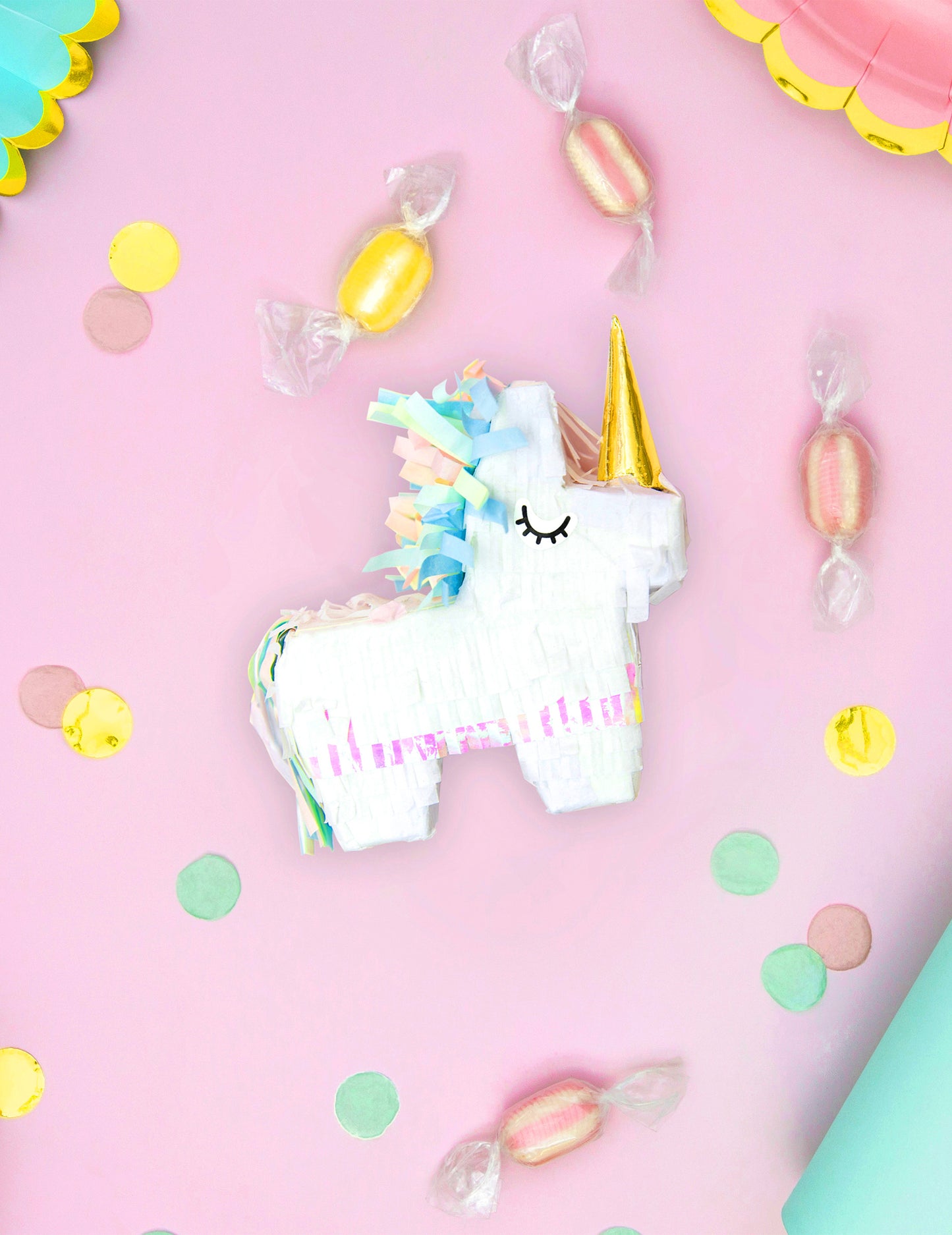 Mise en scène festive avec confettis de la mini piñata licorne blanche