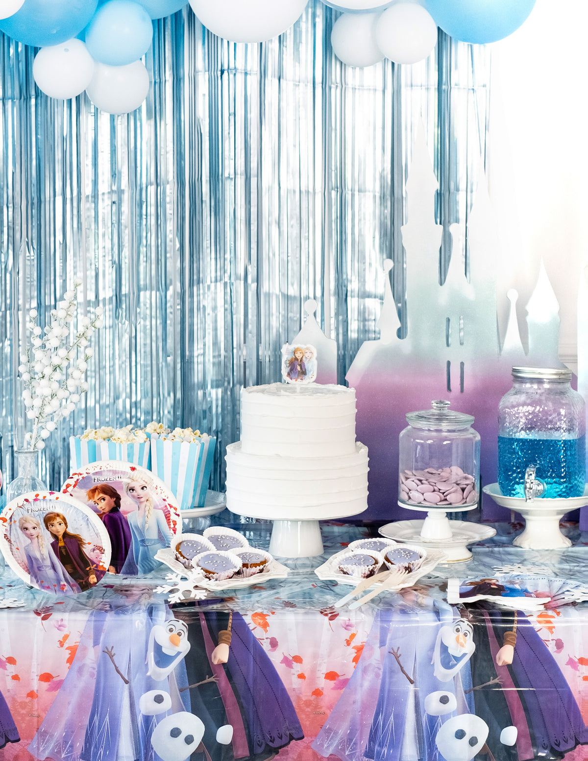 Mise en situation sur une table de fête de la nappe en plastique La Reine des Neiges 2