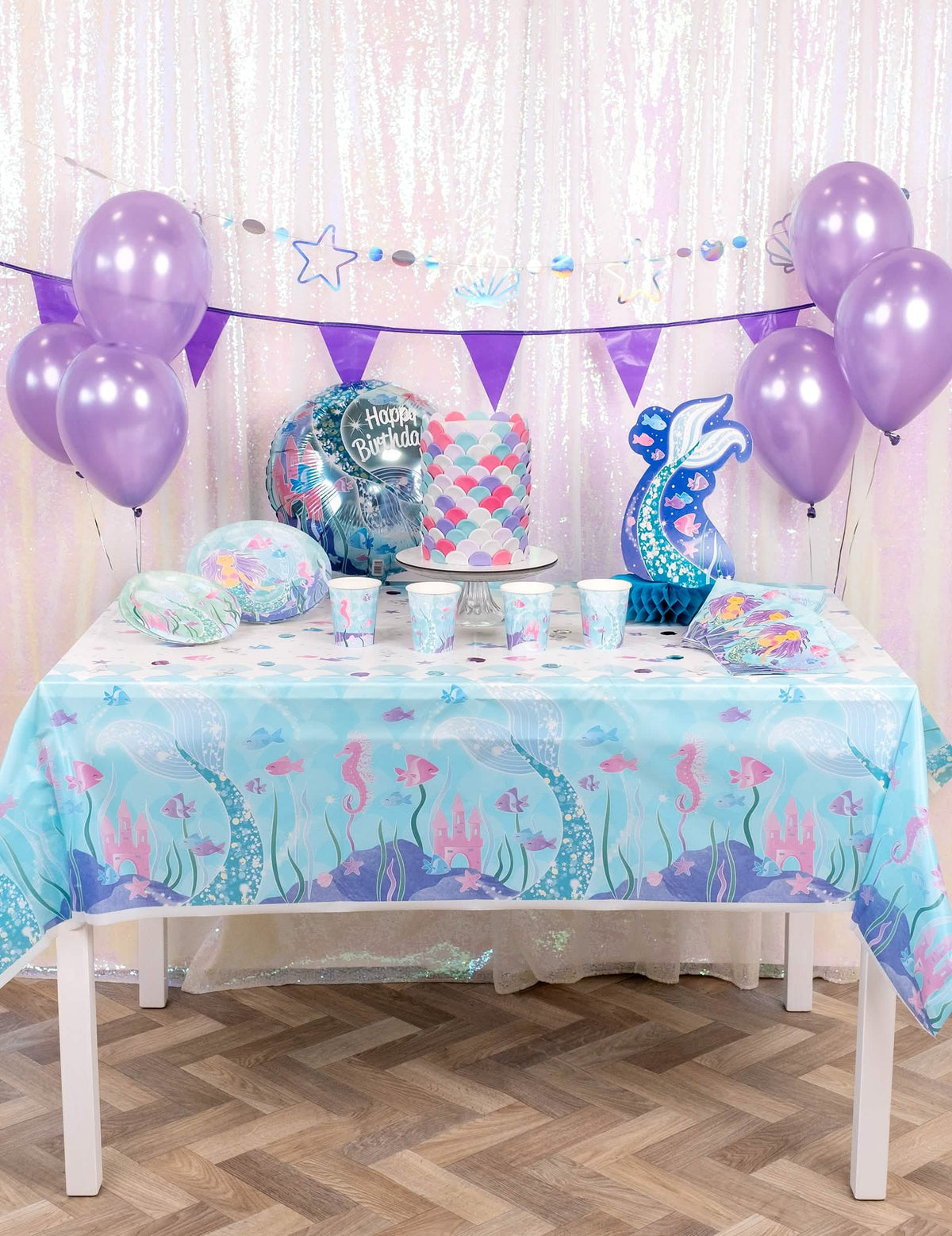 Vista geral da mesa de festa com a bonita toalha de mesa de plástico de sereias