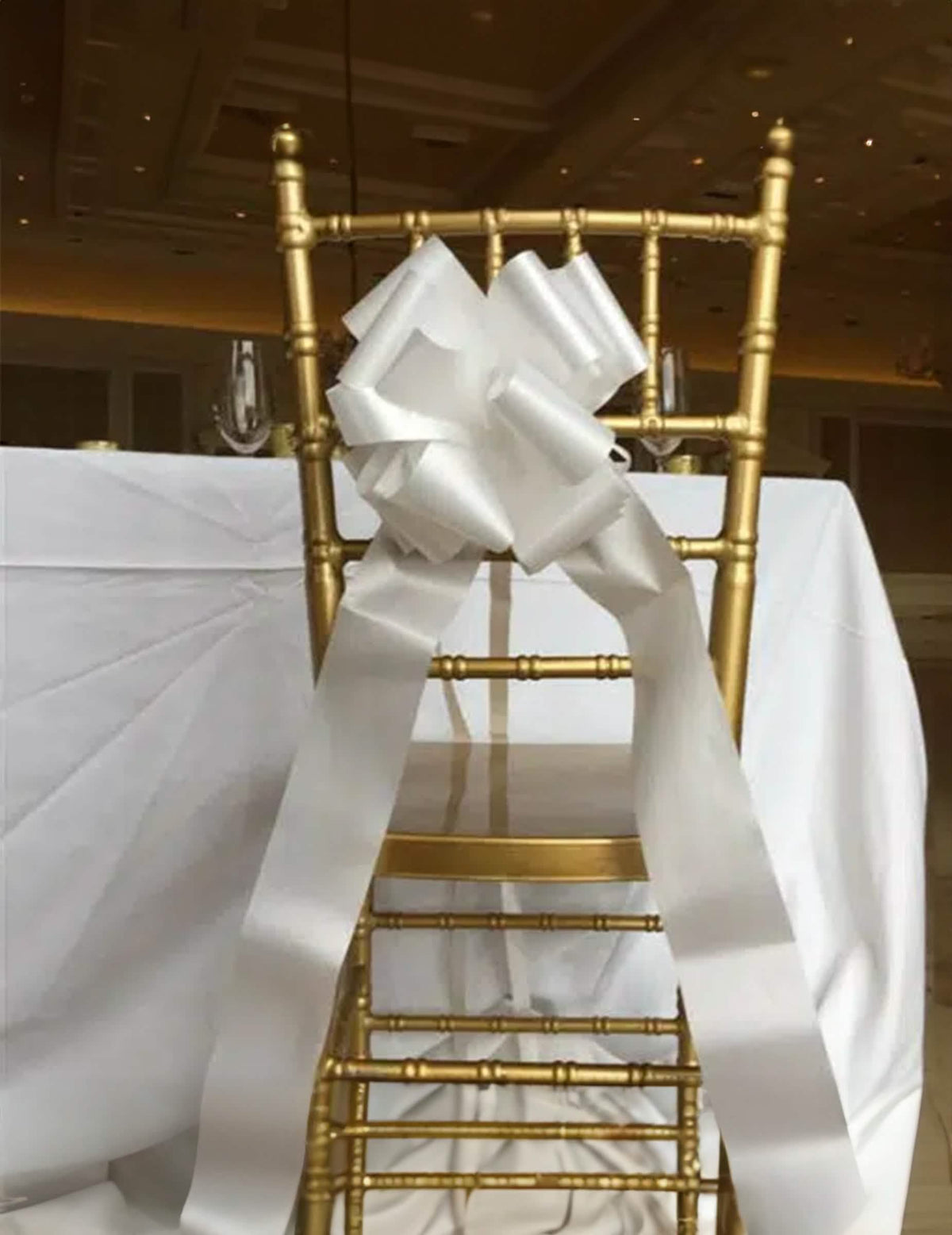 Encenação numa cadeira do laço gigante de puxar para decoração branco efeito cetim