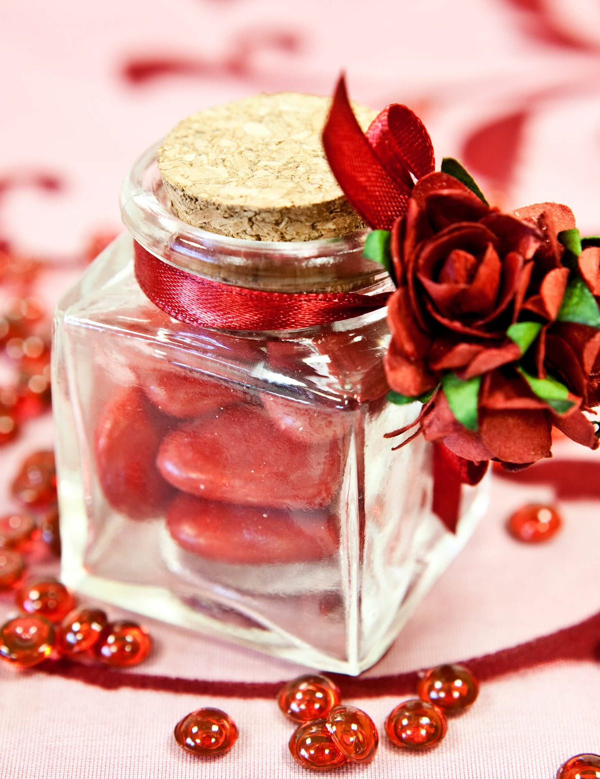 Decoração com fita e rose vermelha do pequeno pote de vidro quadrado para festa