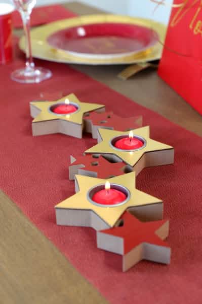 Cenário de mesa do suporte para velas em forma de estrelas para decoração de natal vermelho e dourado em madeira e metal