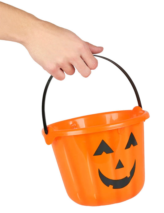 Detalhe da pega segurada por uma mão do balde abóbora para halloween