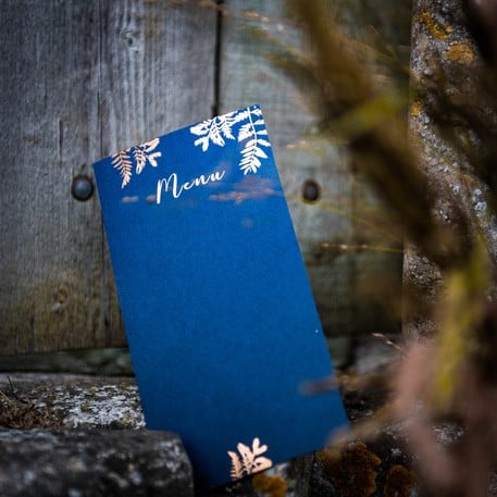 Vue de face du menu fougères pour mariage bleu marine et cuivre