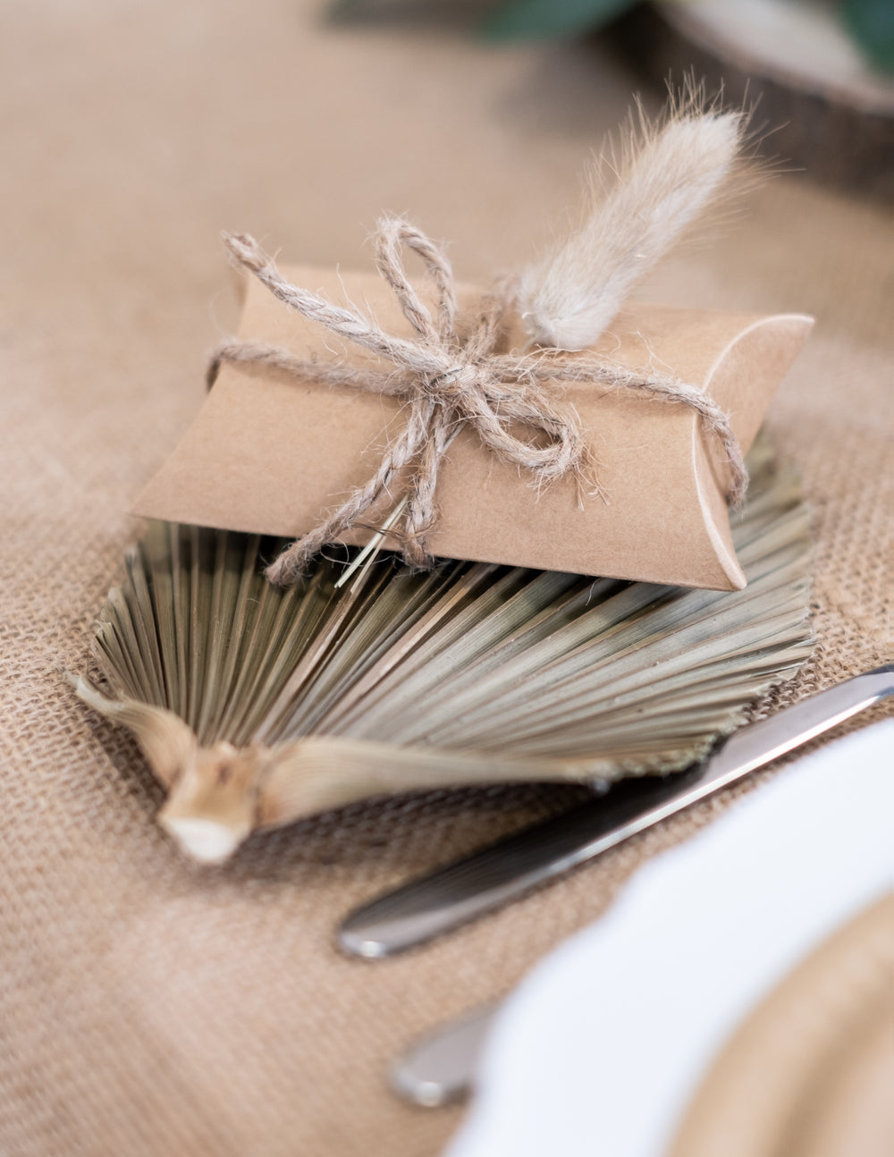 Détail de la décoration avec feuille de palmier des petites boîtes kraft pour fête