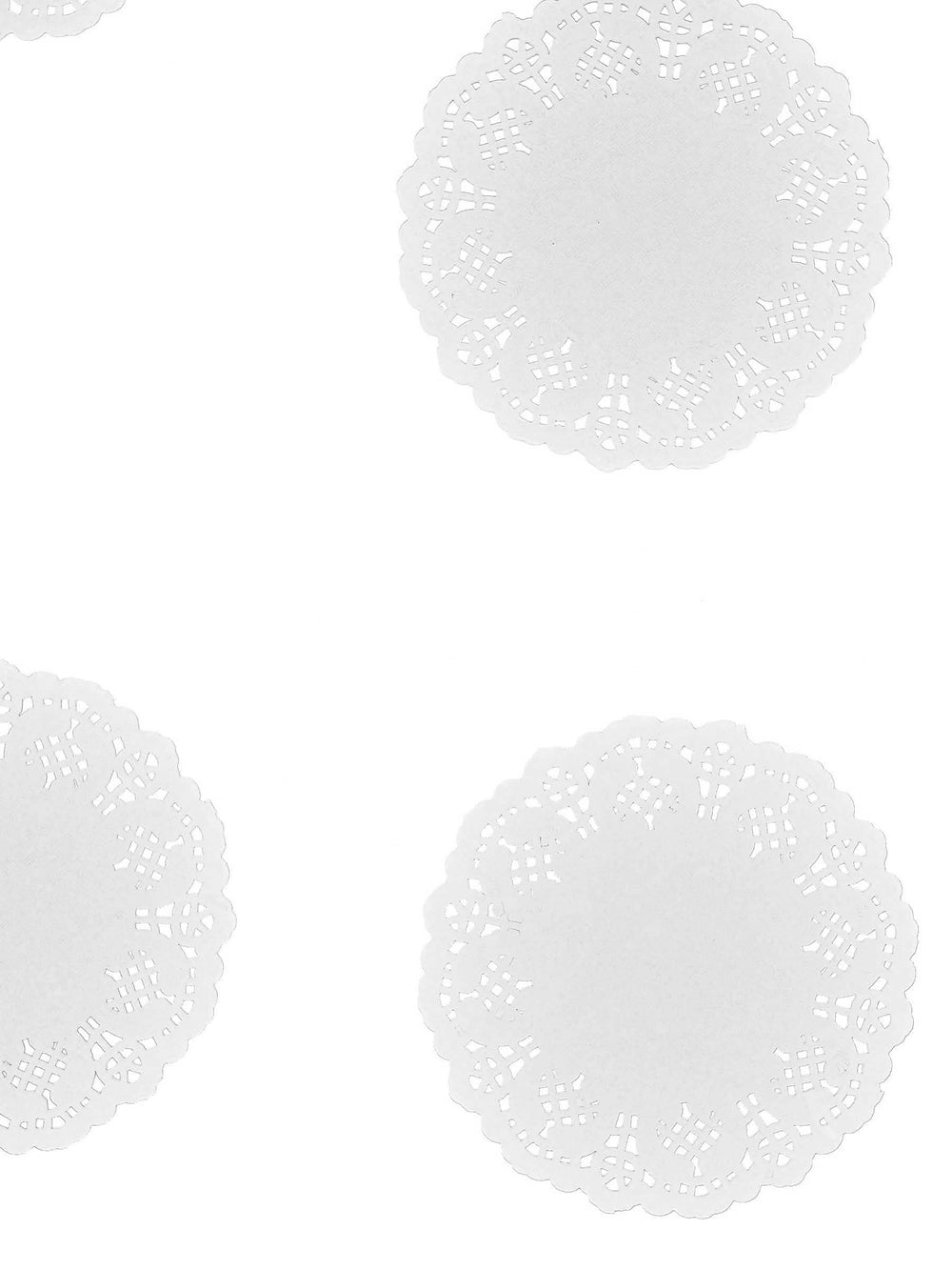 Vista de vários exemplares dos pequenos napperons de papel de renda branco