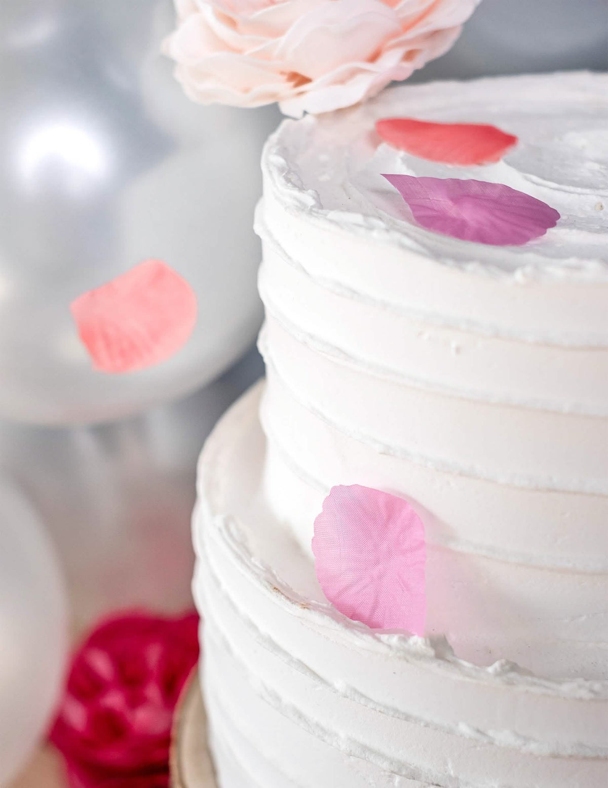 Cenário num bolo com pétalas cor de rosa de tecido para casamento fúcsia