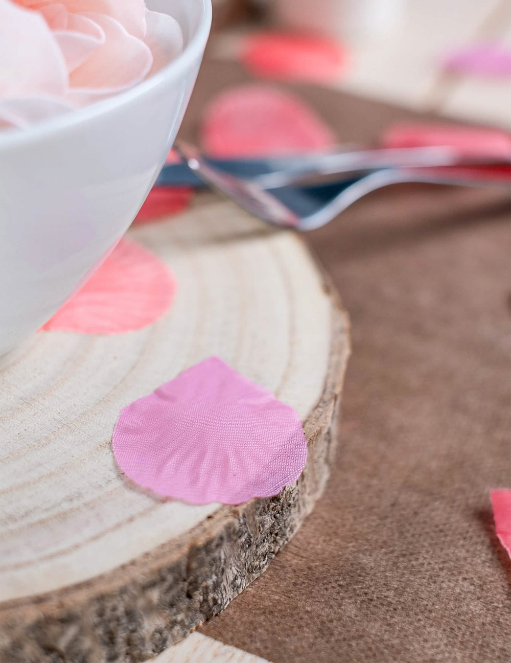 Detalhe de uma pétala numa rodela de madeira dos pétalas de cor de rosa para casamento em tecido fúcsia